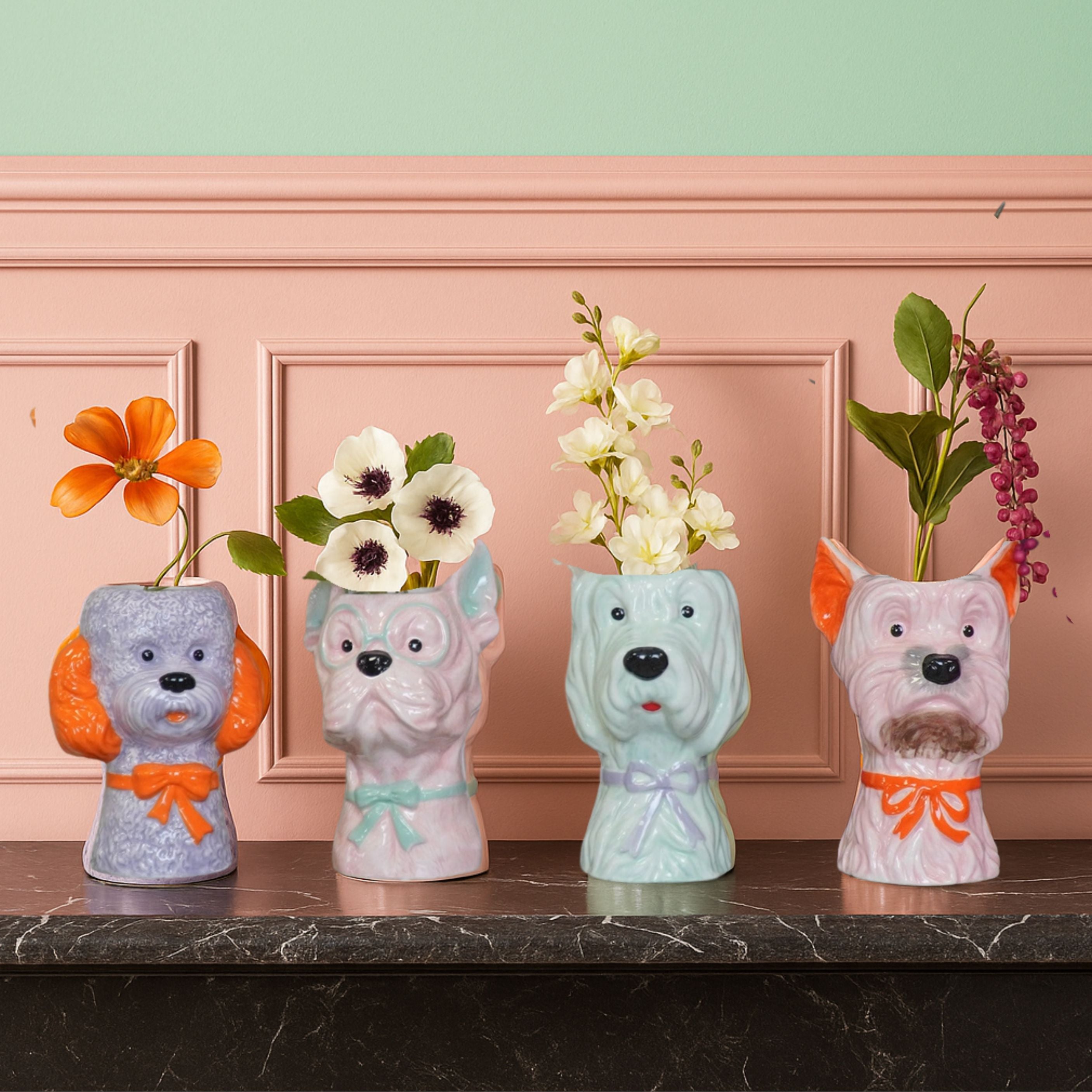 Colourful dog-shaped ceramic flower vases with floral arrangements on a marble mantel in a pastel pink and mint room.