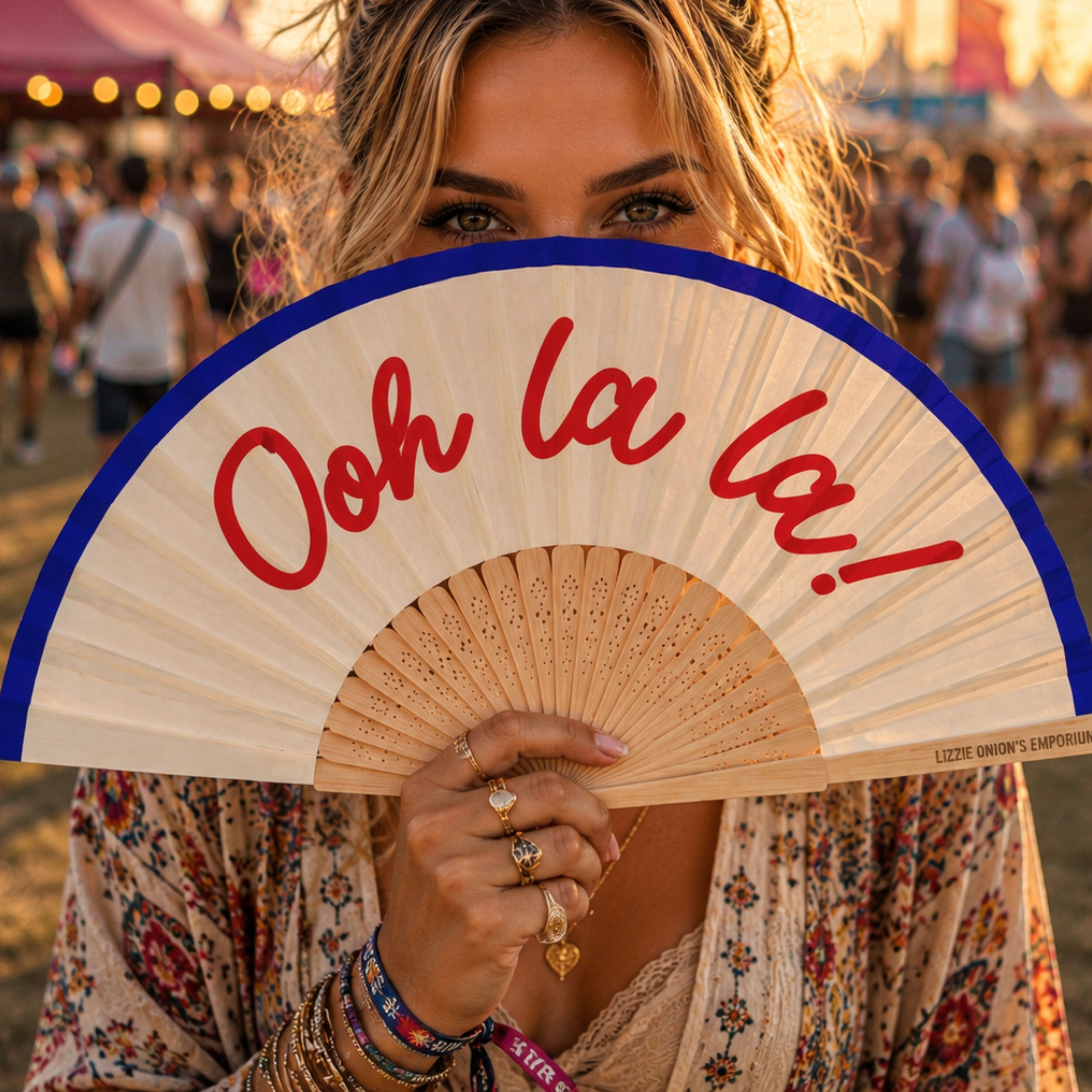 Fantastico Fans Ibiza hand fan with Ooh la la slogan held by woman at outdoor summer festival.