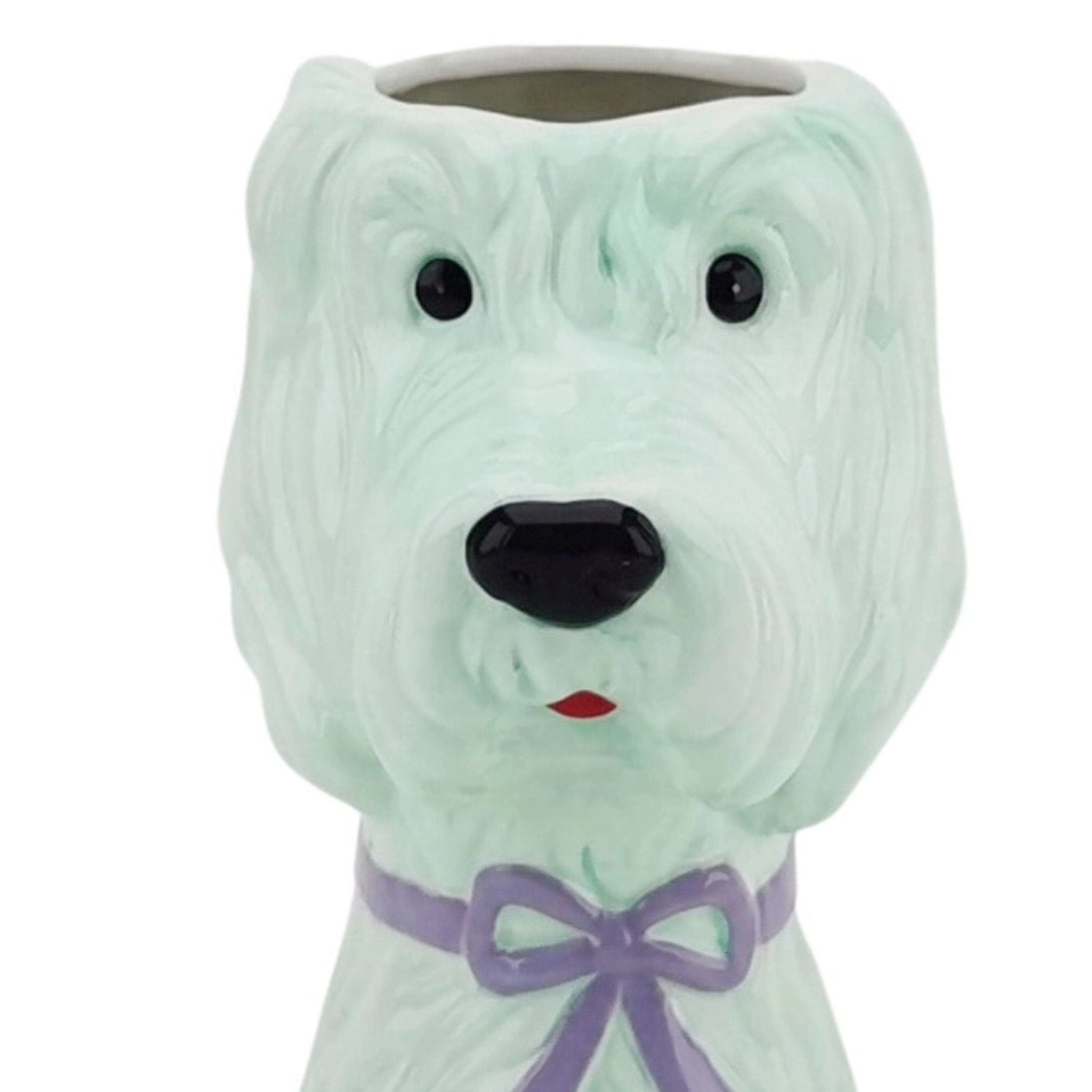 Close-up of a cute mint green dog-shaped vase with a lilac bow, decorative ceramic homeware on a white background.