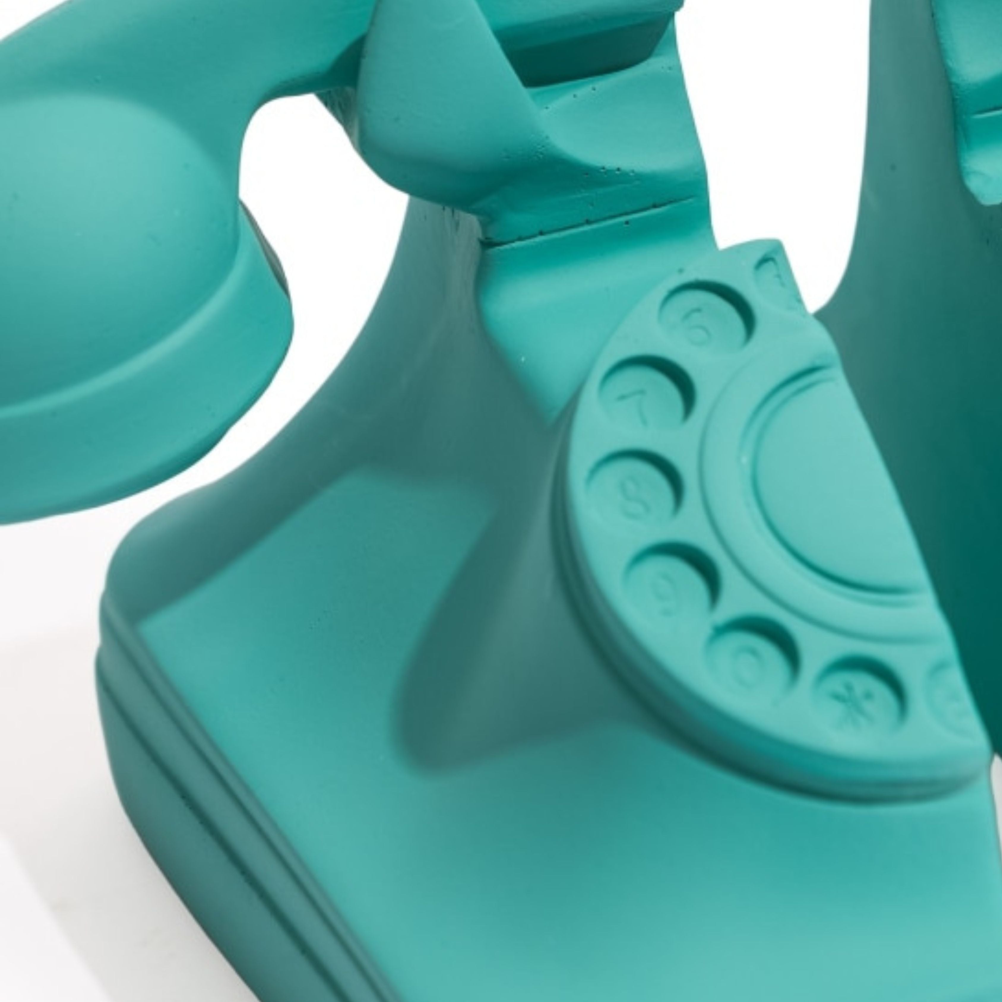 Close up of matt aqua blue retro rotary telephone bookend detail on white background