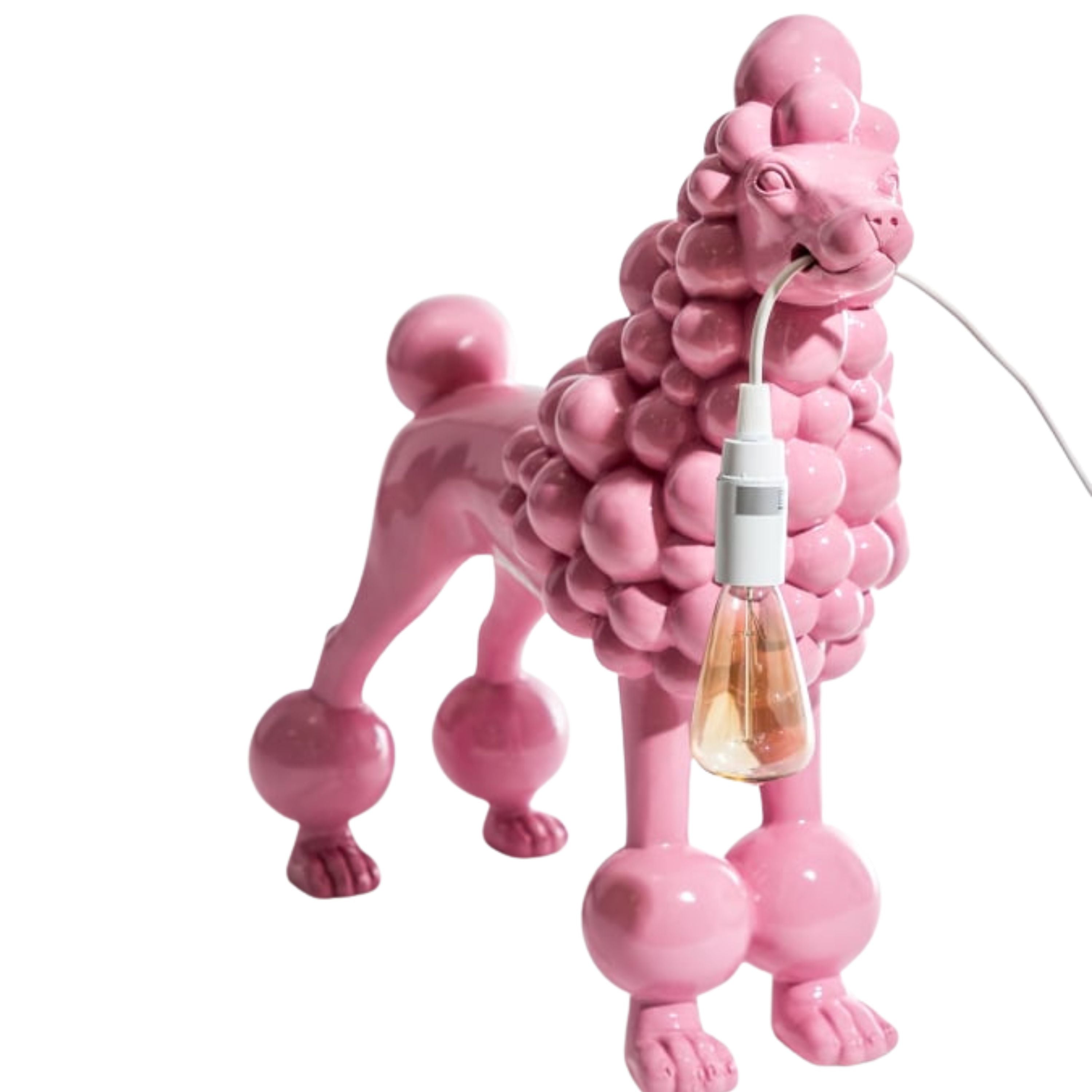 Glossy pink resin poodle lamp standing with a light bulb held in its mouth, photographed on a white background.