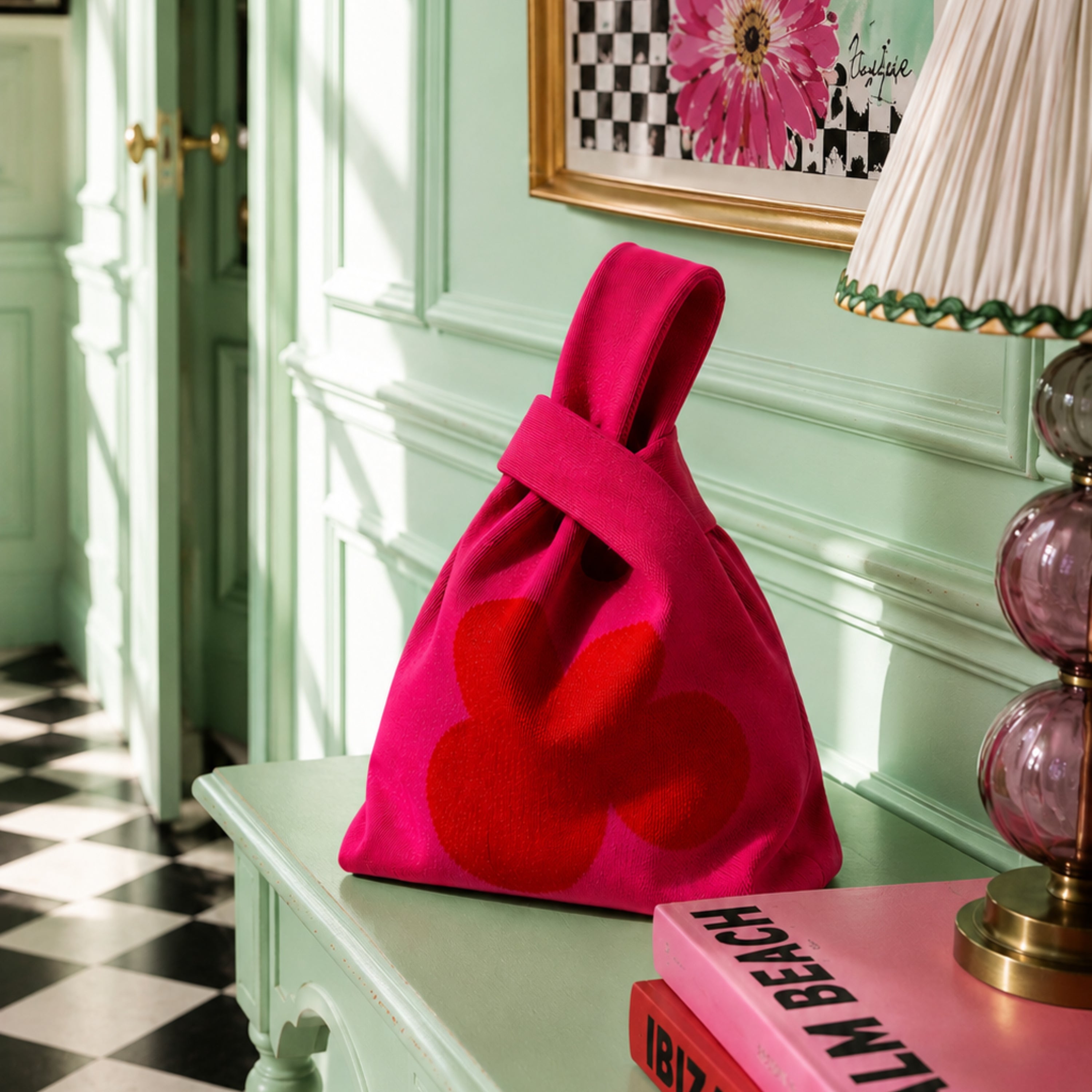 Pink knitted tote bag with oversized red abstract flower design, styled on a mint green console table in a colourful maximalist interior by Lizzie Onion's Emporium.