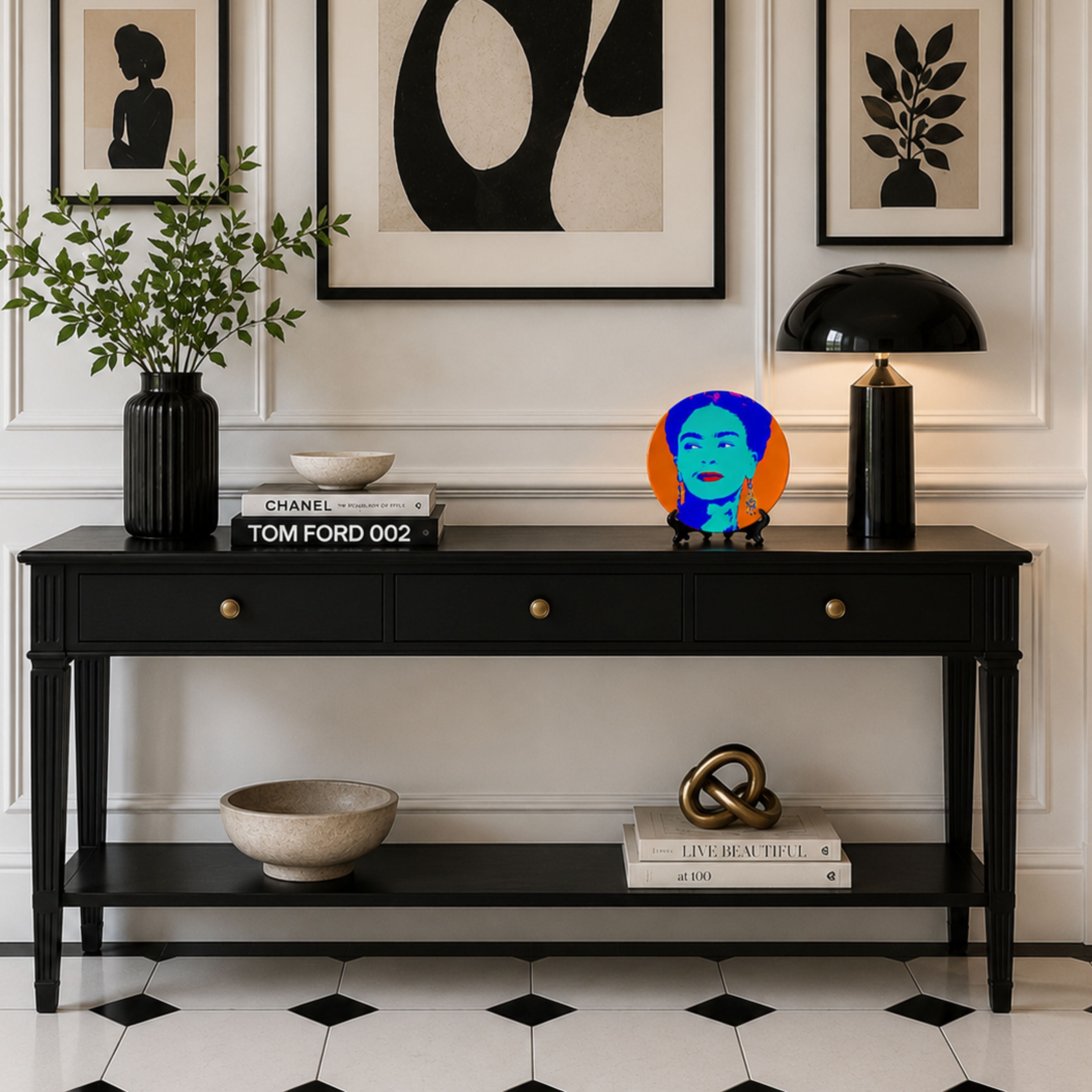 Pop art inspired Frida Kahlo decorative plate styled on a black console table with monochrome artwork, white panelled walls and black and white tiled flooring