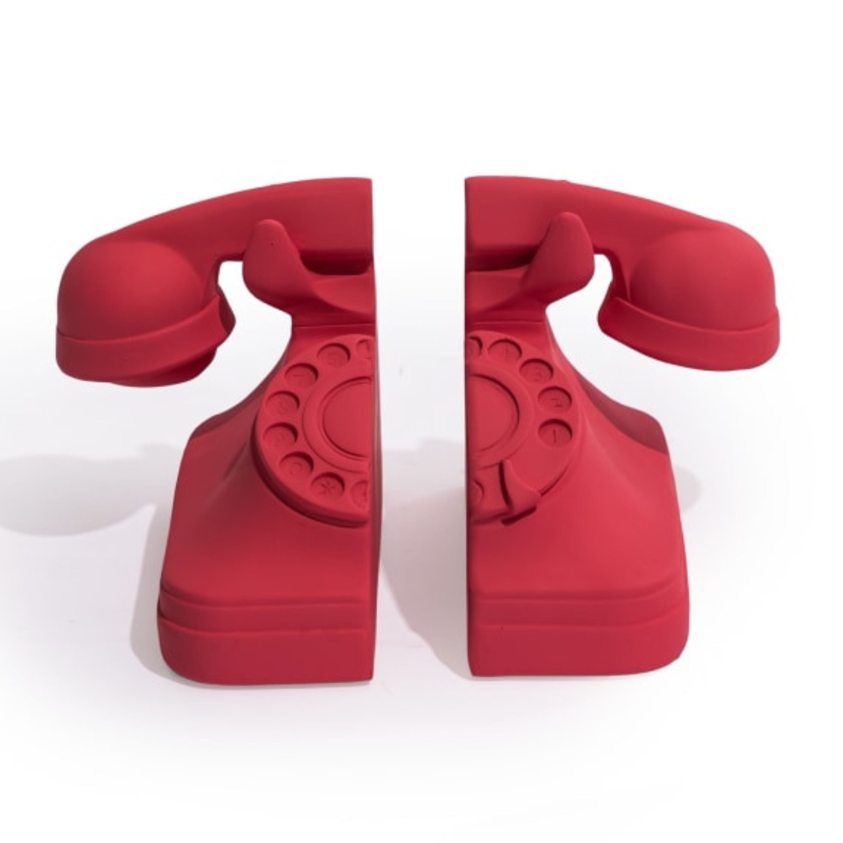 Set of matt pink red retro telephone bookends on white background