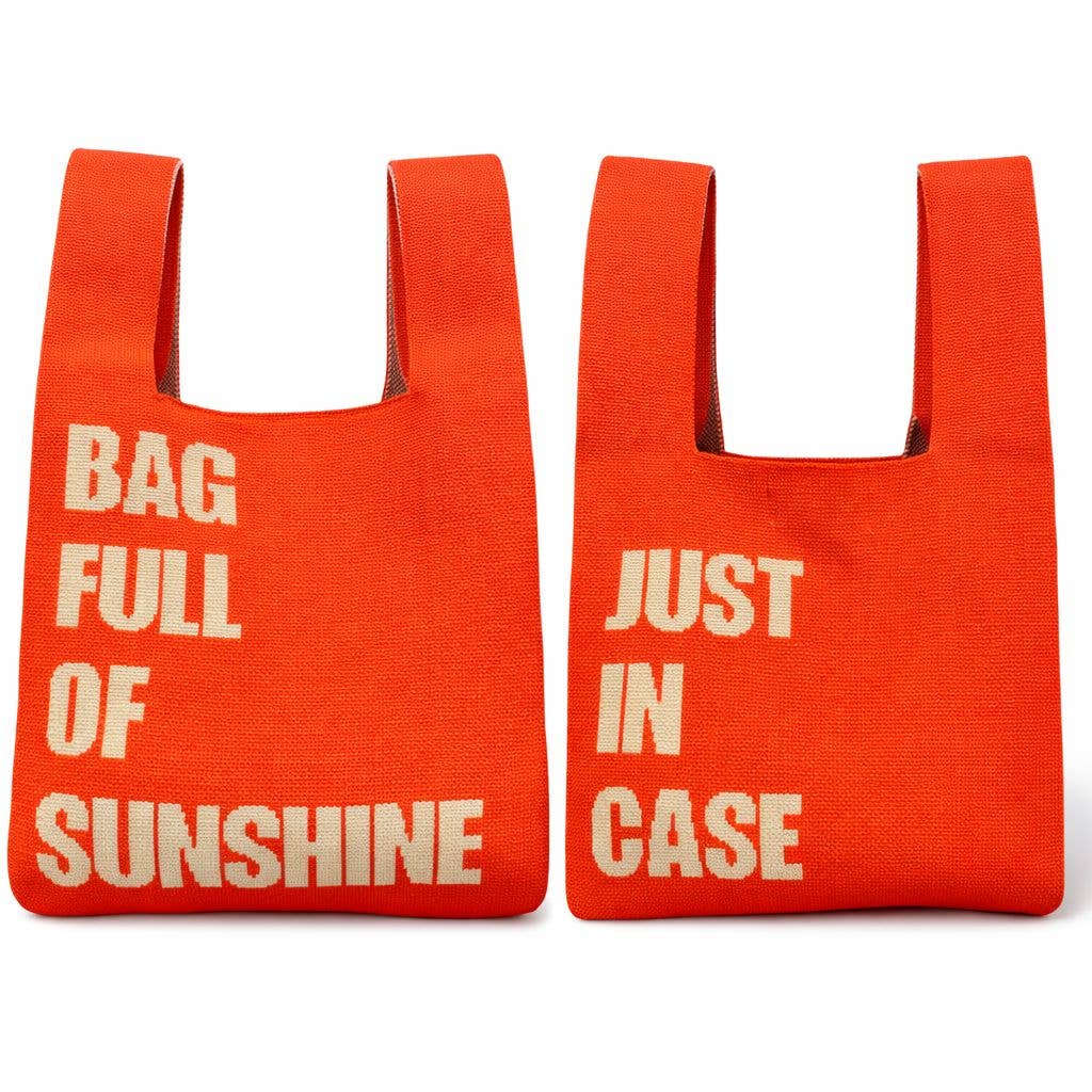 Two orange knitted statement bags with bold white typography reading "Bag Full of Sunshine" and "Just In Case", featuring integrated handles and a lightweight reusable design on a white background.