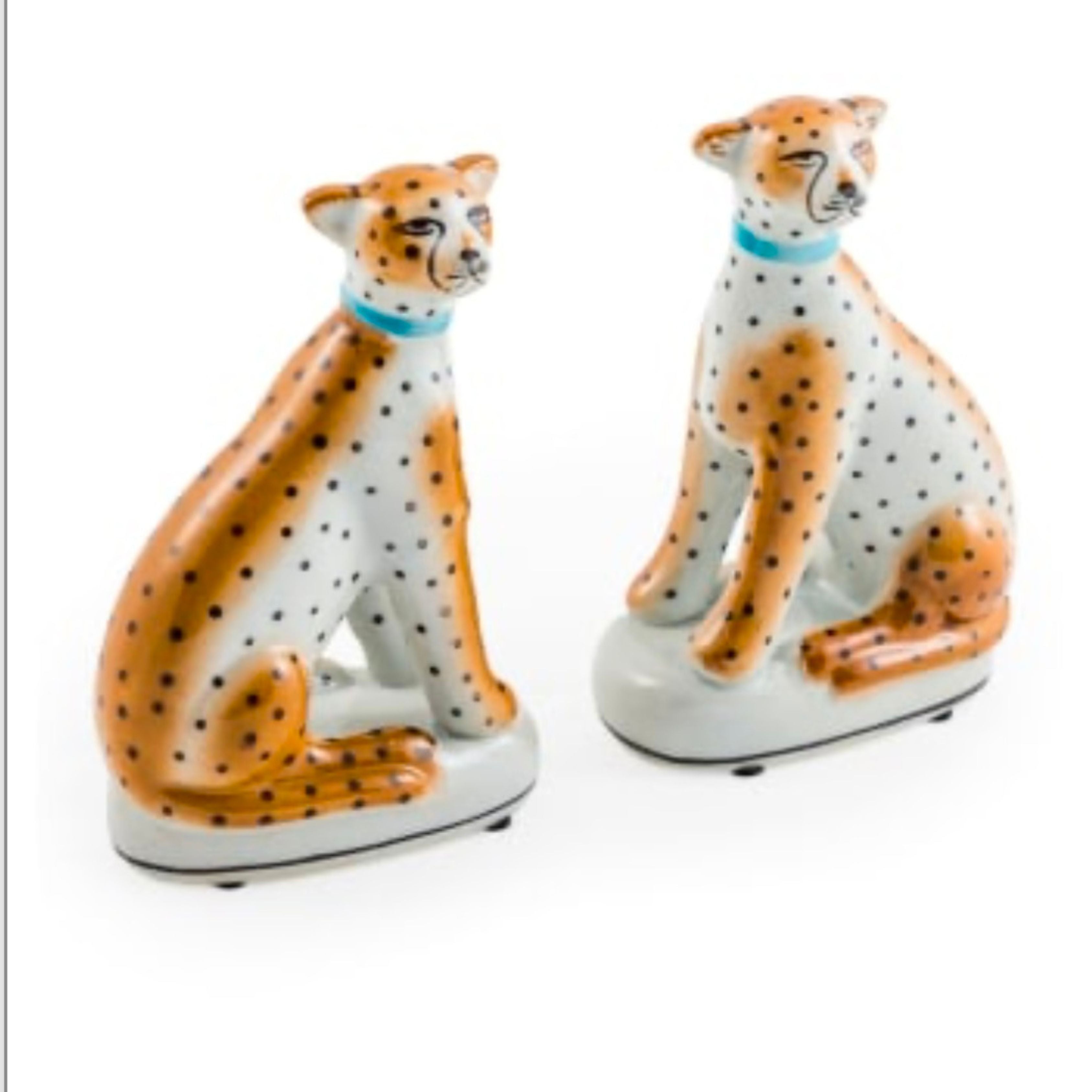 pair of ceramic leopard ornaments sitting with orange and black spots decorative animal figures on white background