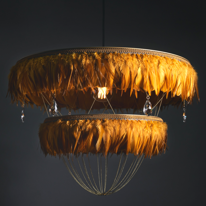 Mustard yellow two-tier Bertie feather light shade with crystal drops softly glowing against a dark background.